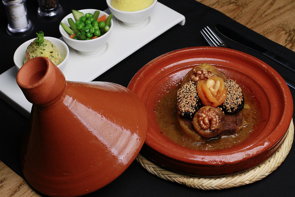 Lamb tajine with walnuts and dried fruits served in a clay pot