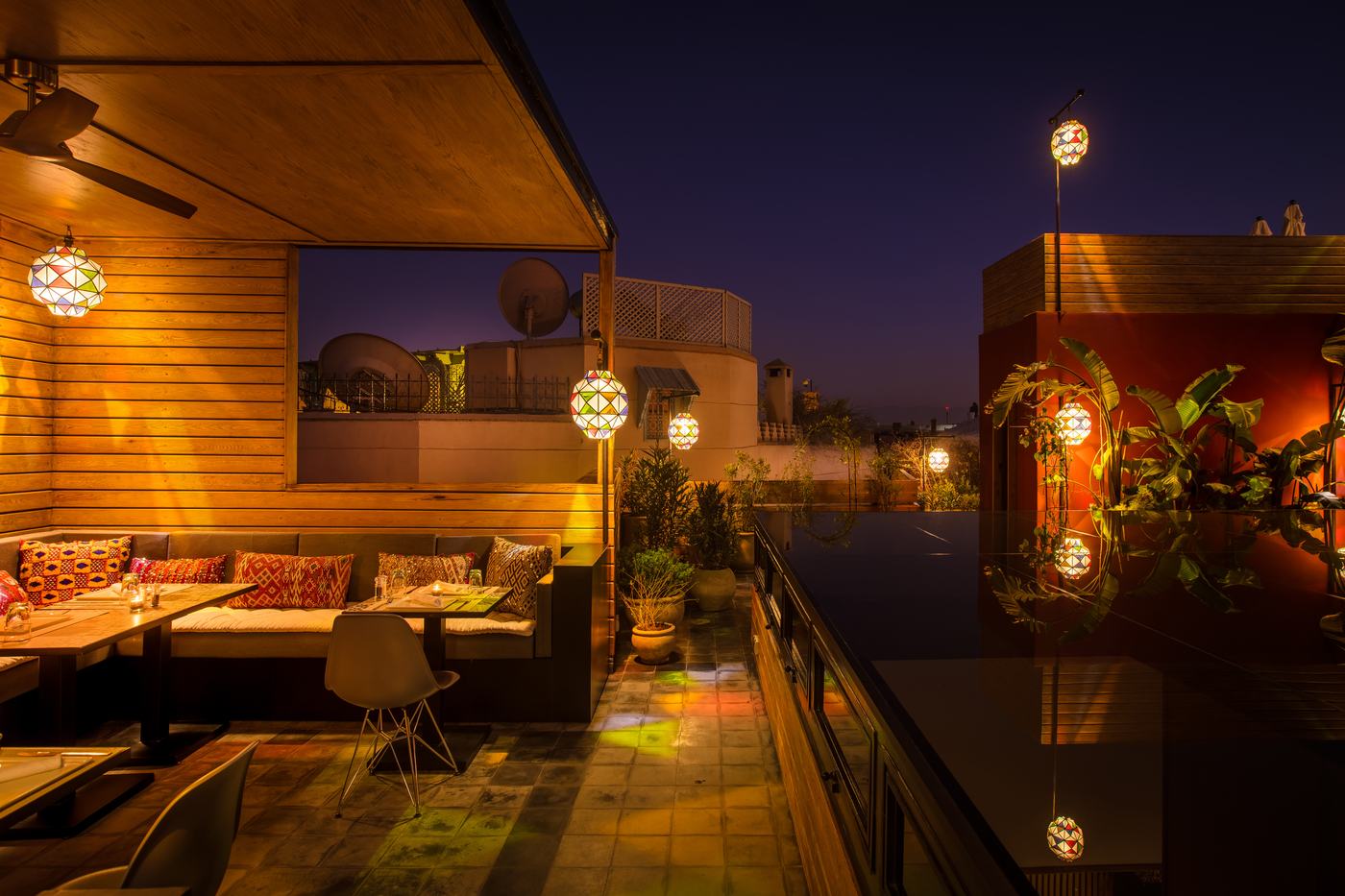 Tables on the rooftop terrace at dusk, lanterns lit